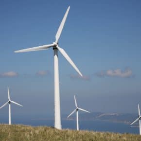 Four wind turbines on top of a hill.