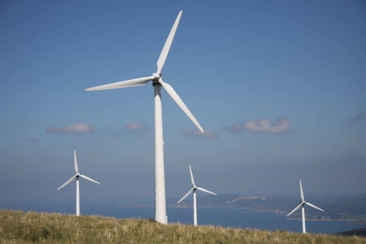 Four wind turbines on top of a hill.