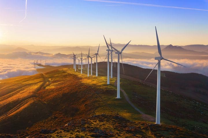 Wind turbines on top of a picturesque hillside.