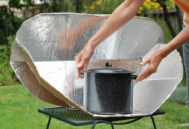 Somebody using a portable solar cooker.