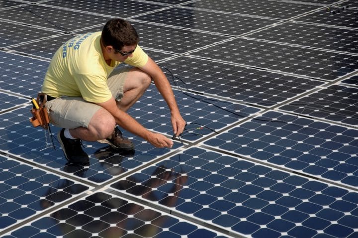 Somebody installing a monocrystalline silicon solar panel.
